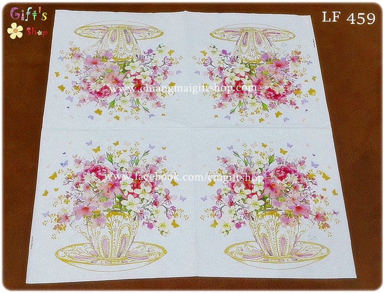 กระดาษแนปกิ้น ลายดอกไม้เล็ก ๆ สีแดง ชมพู ครีมหลายดอกในแก้วกาแฟสีขาวลายทองชมพูมีจานรองแก้ว ผีเสื้อเล็ก ๆ บินวน พื้นหลังสีขาว